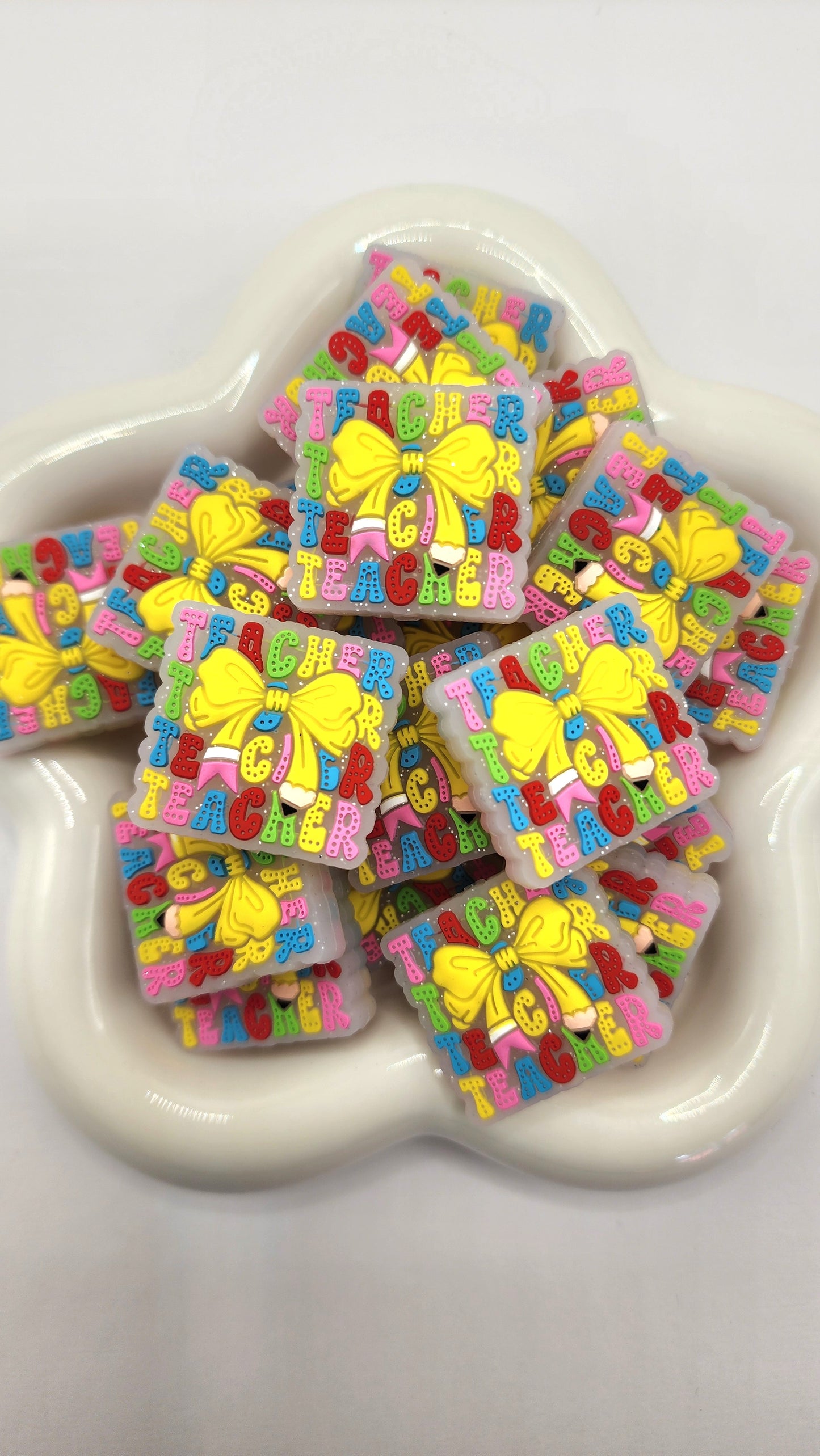 Square Teacher Pencil Bow silicone focal bead to use on diy and crafts projects including beaded pens, wristlets, earrings, keychains and bracelets.