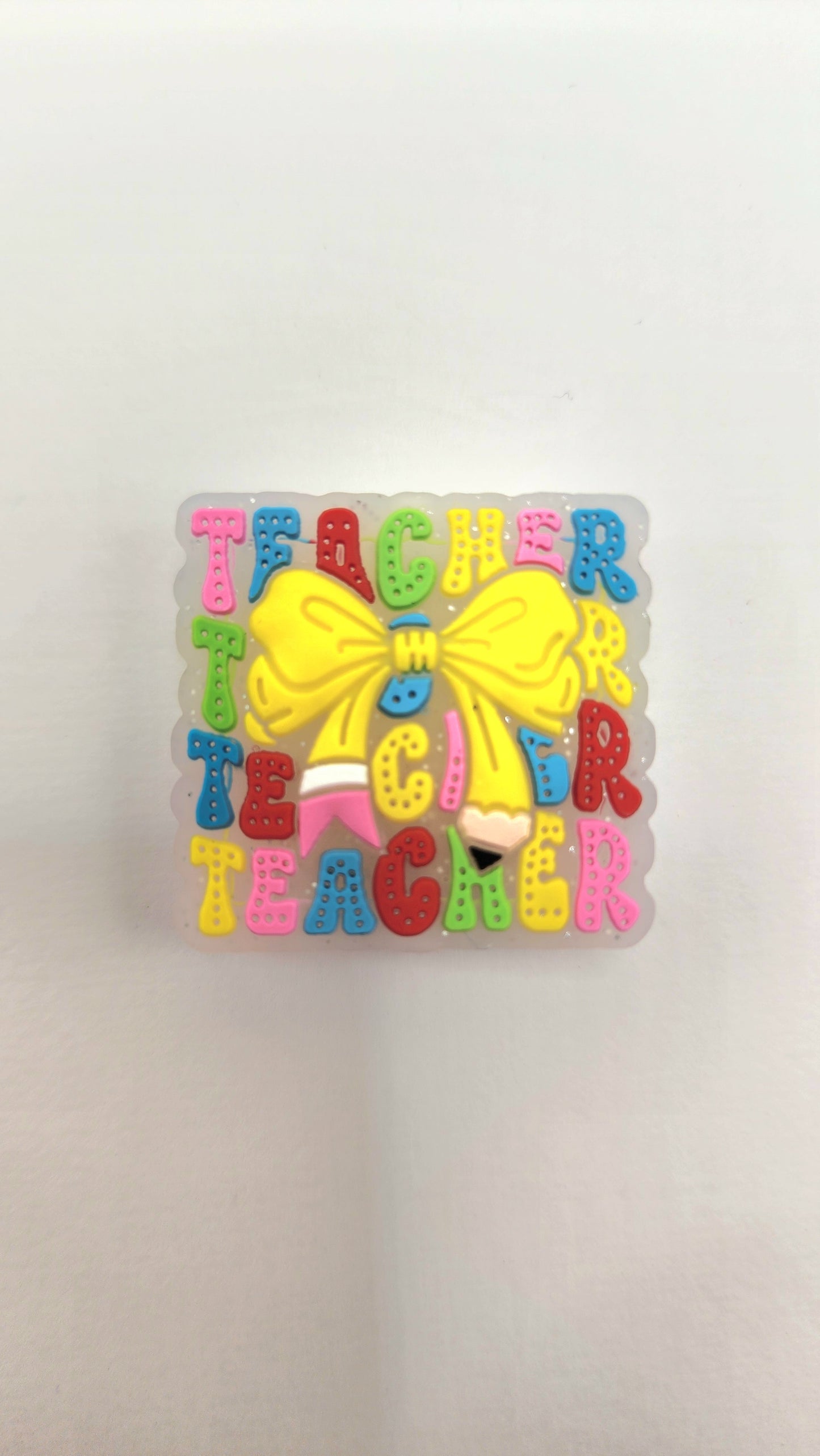 Square Teacher Pencil Bow silicone focal bead to use on diy and crafts projects including beaded pens, wristlets, earrings, keychains and bracelets.