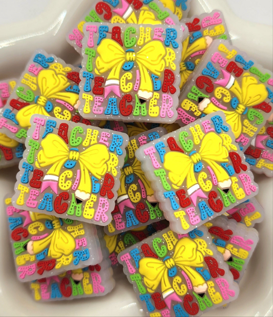 Square Teacher Pencil Bow silicone focal bead to use on diy and crafts projects including beaded pens, wristlets, earrings, keychains and bracelets. 