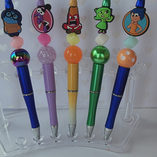 Five writing pen set with fun feelings silicone focal beads. Write in black ink and includes one extra refill for each pen.