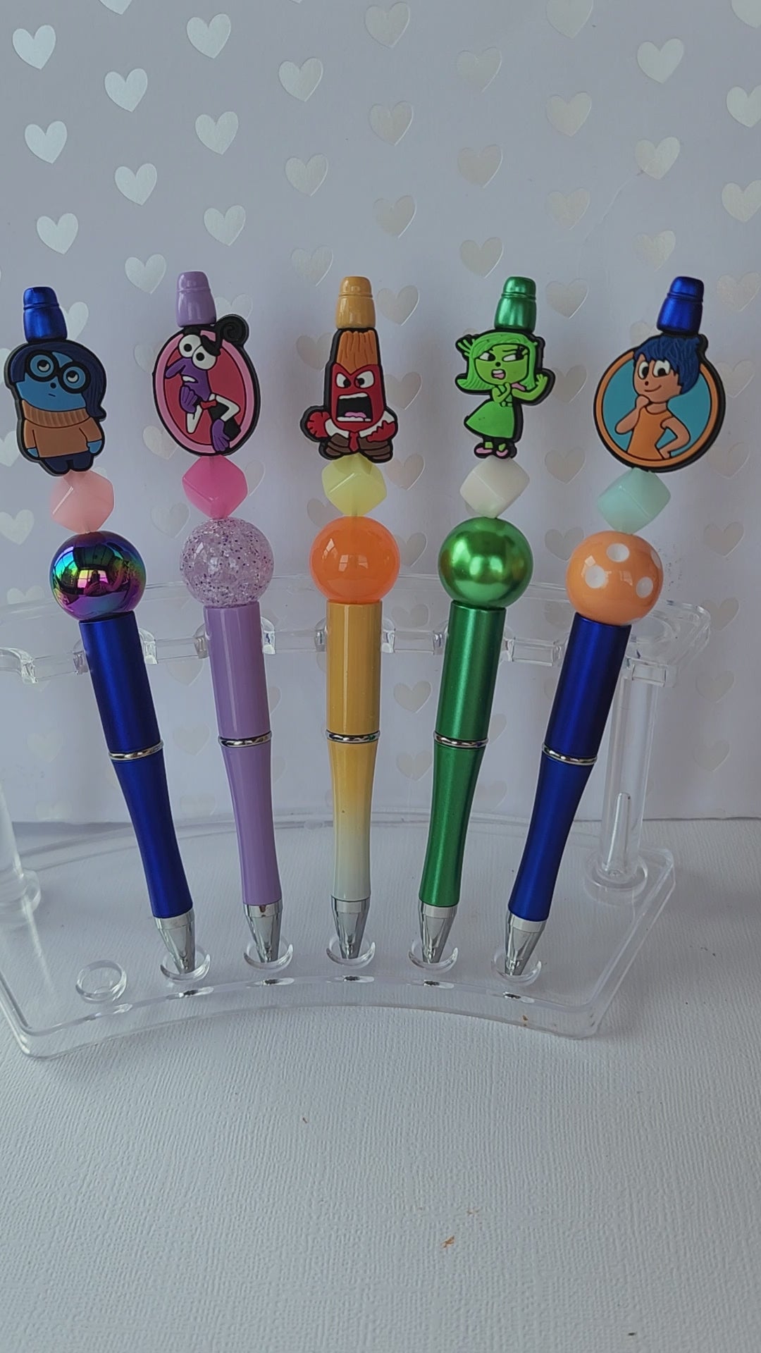 Five writing pen set with fun feelings silicone focal beads. Write in black ink and includes one extra refill for each pen.