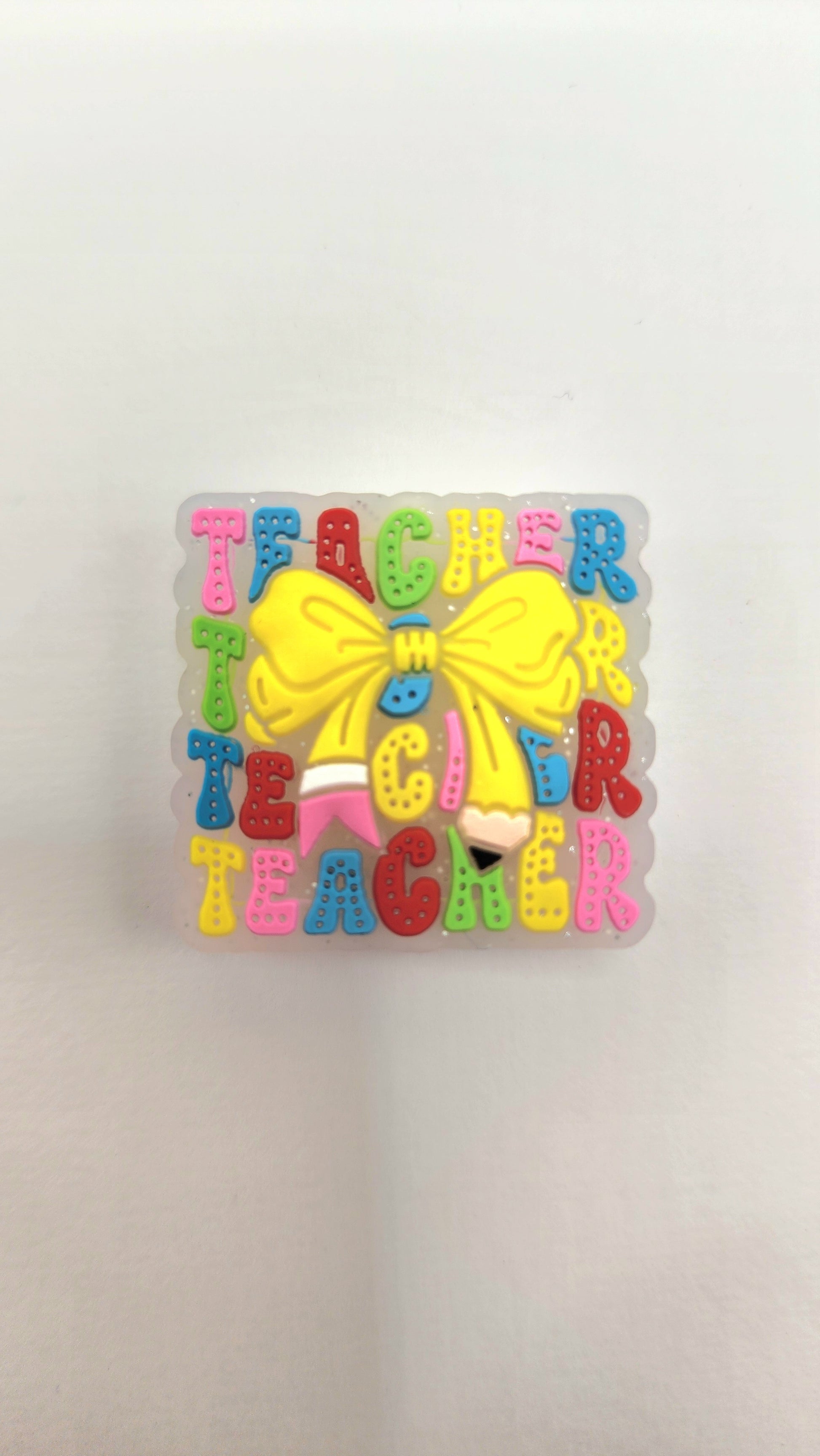 Square Teacher Pencil Bow silicone focal bead to use on diy and crafts projects including beaded pens, wristlets, earrings, keychains and bracelets. 
